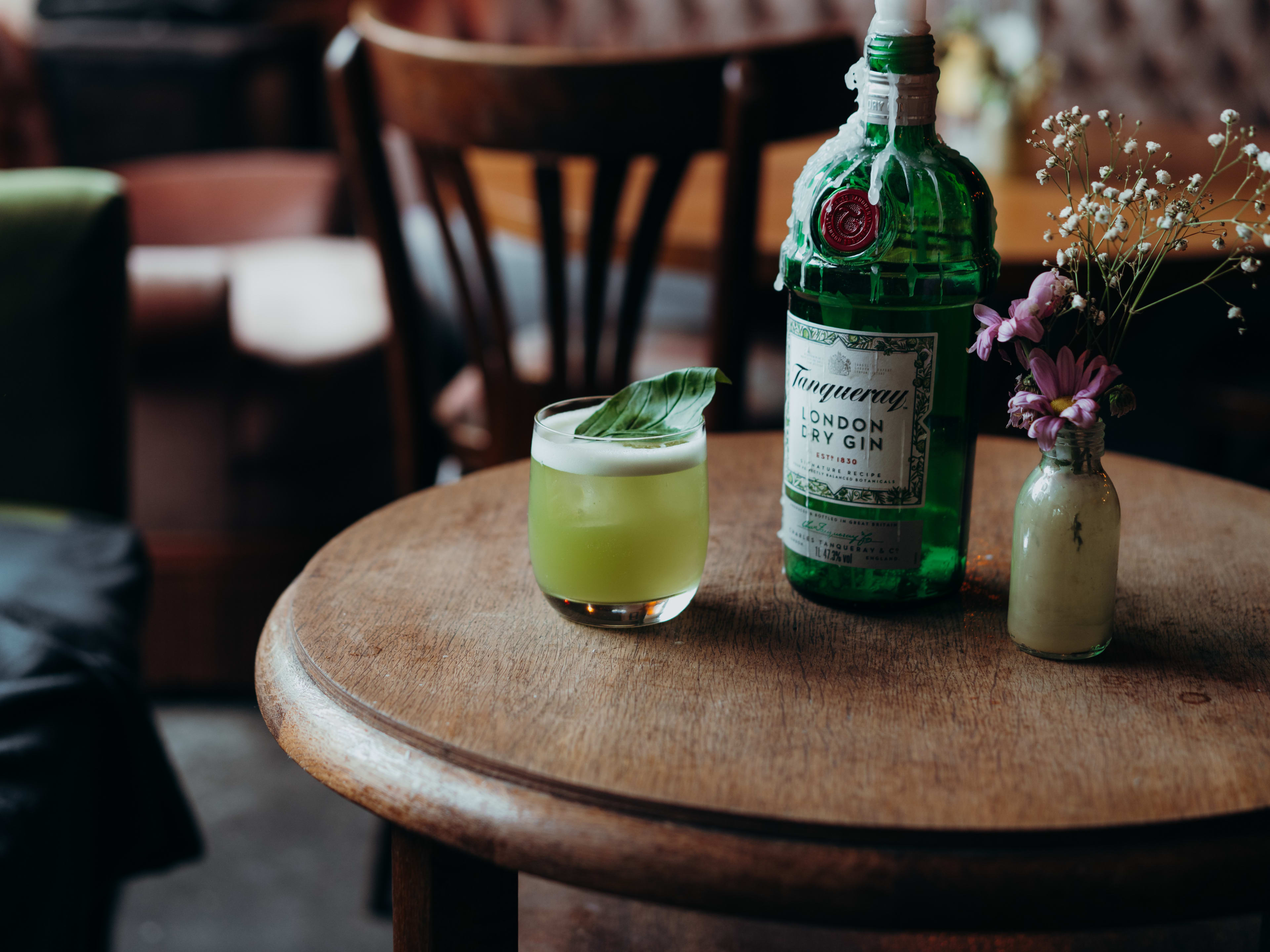 Gin basil smash and bottle of Tanqueray gin at Villa Neukolln