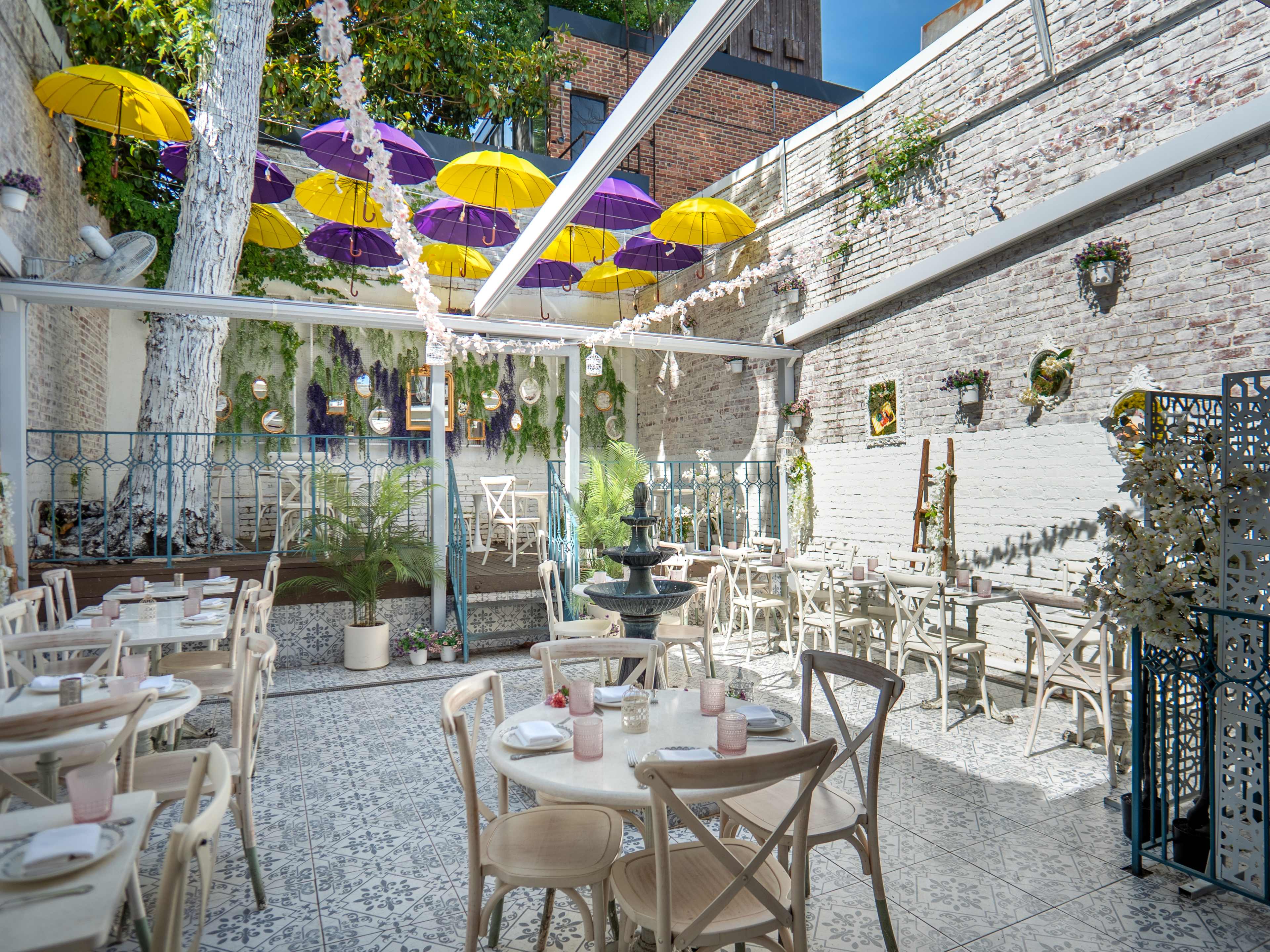 outdoor courtyard with hanging umbrellas and string lights above