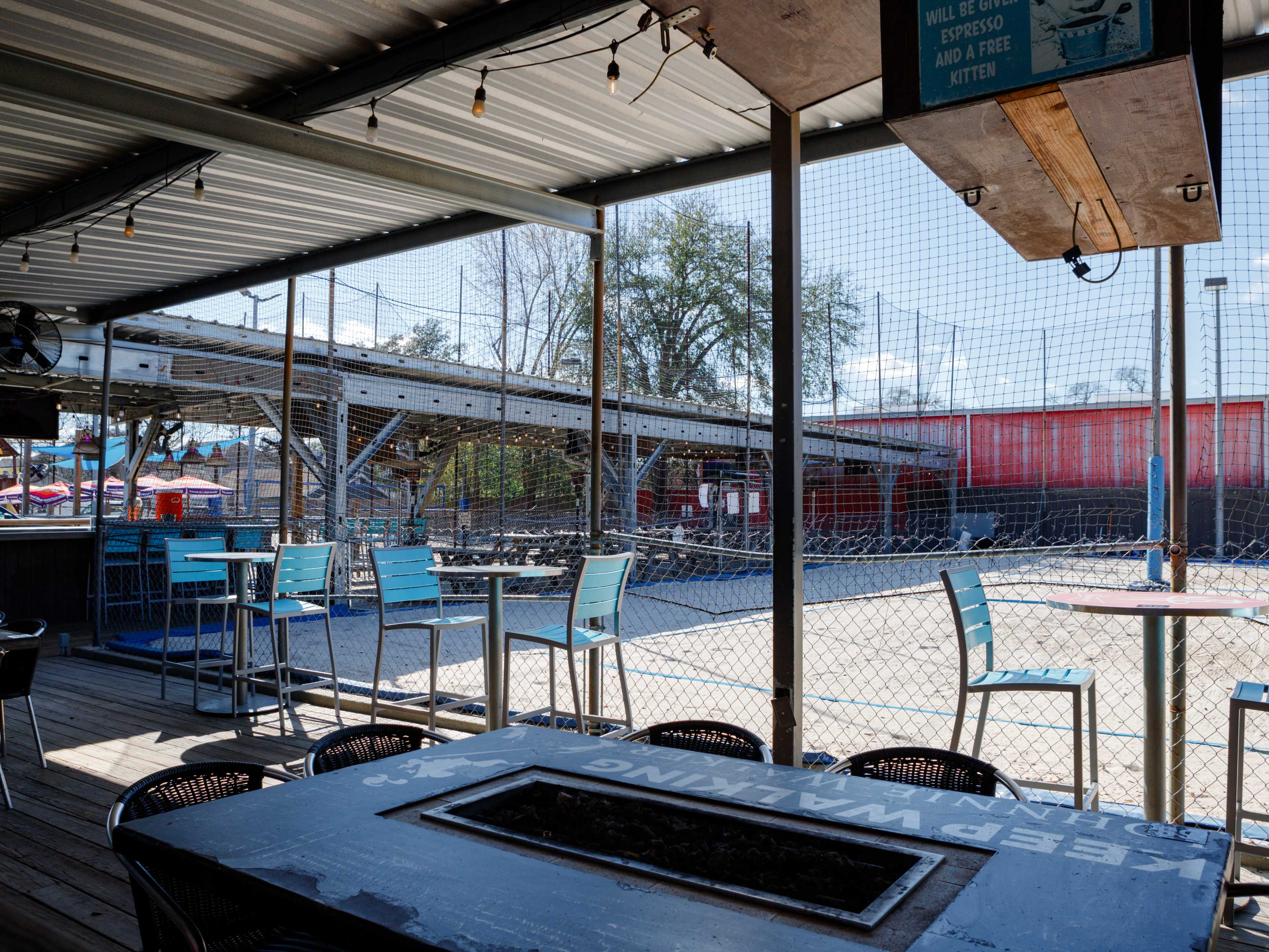 The covered seating area at Wakefield Crowbar. There are fireplaces, heaters, and closed in volley ball courts on sand.