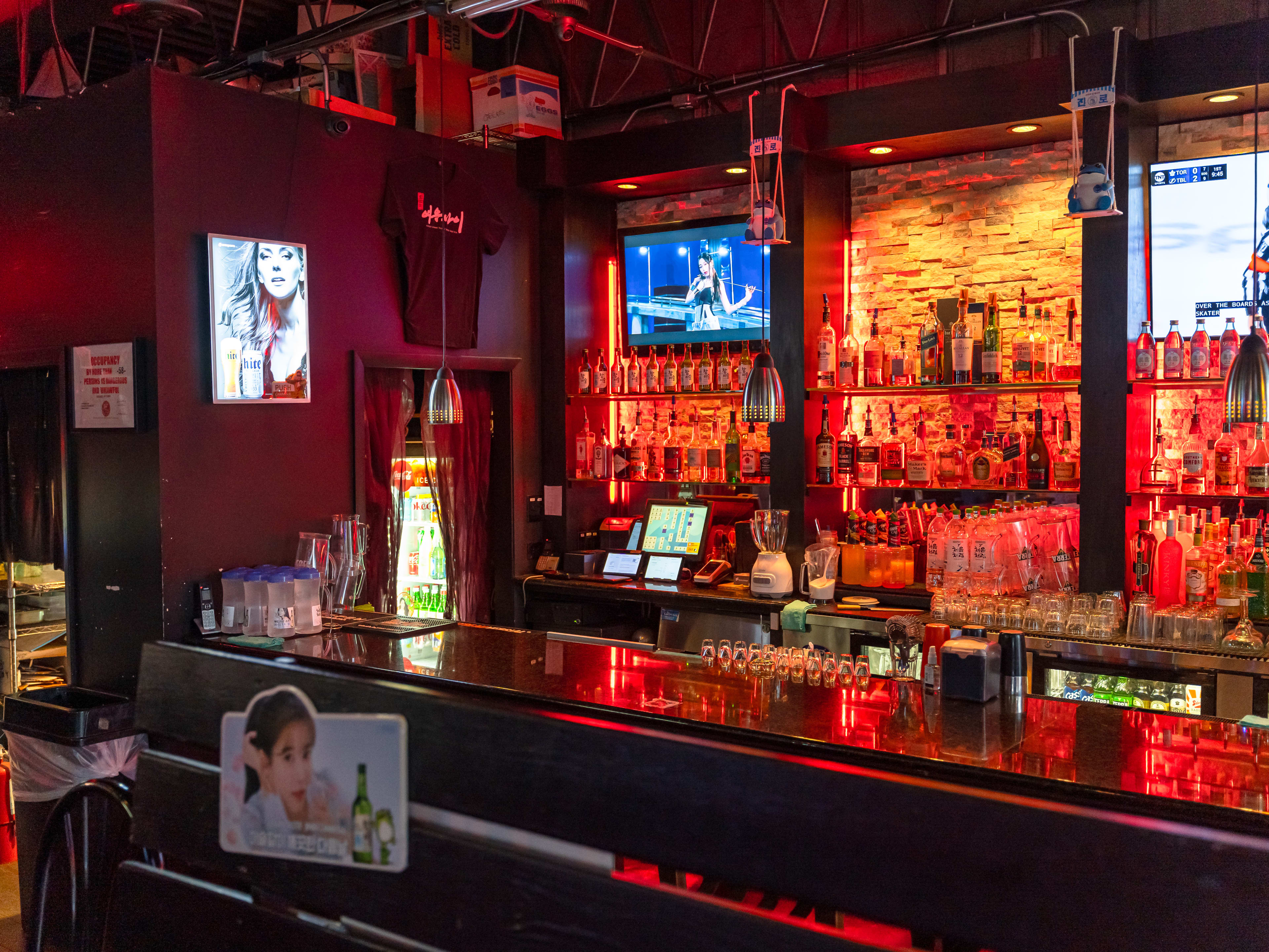 A dimly lit bar with some TVs in the background.