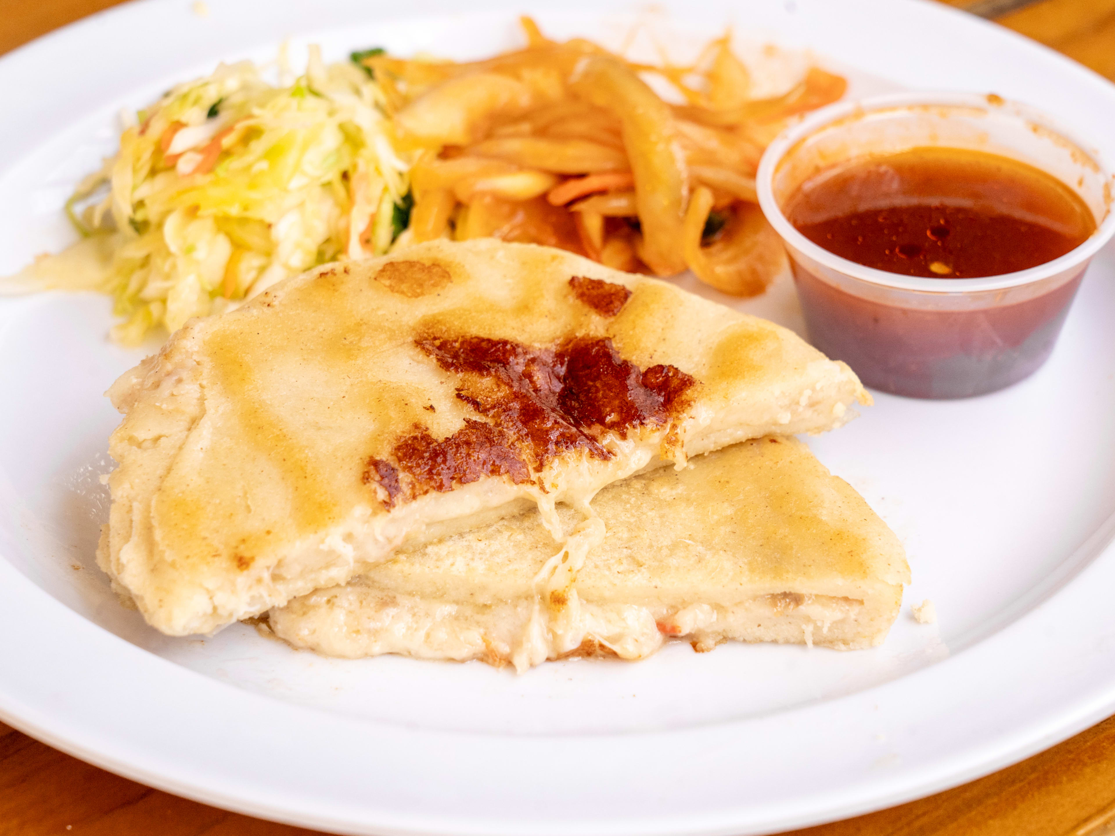 Cheese pupusa, with red salsa, pickled vegetables, and cabbage.