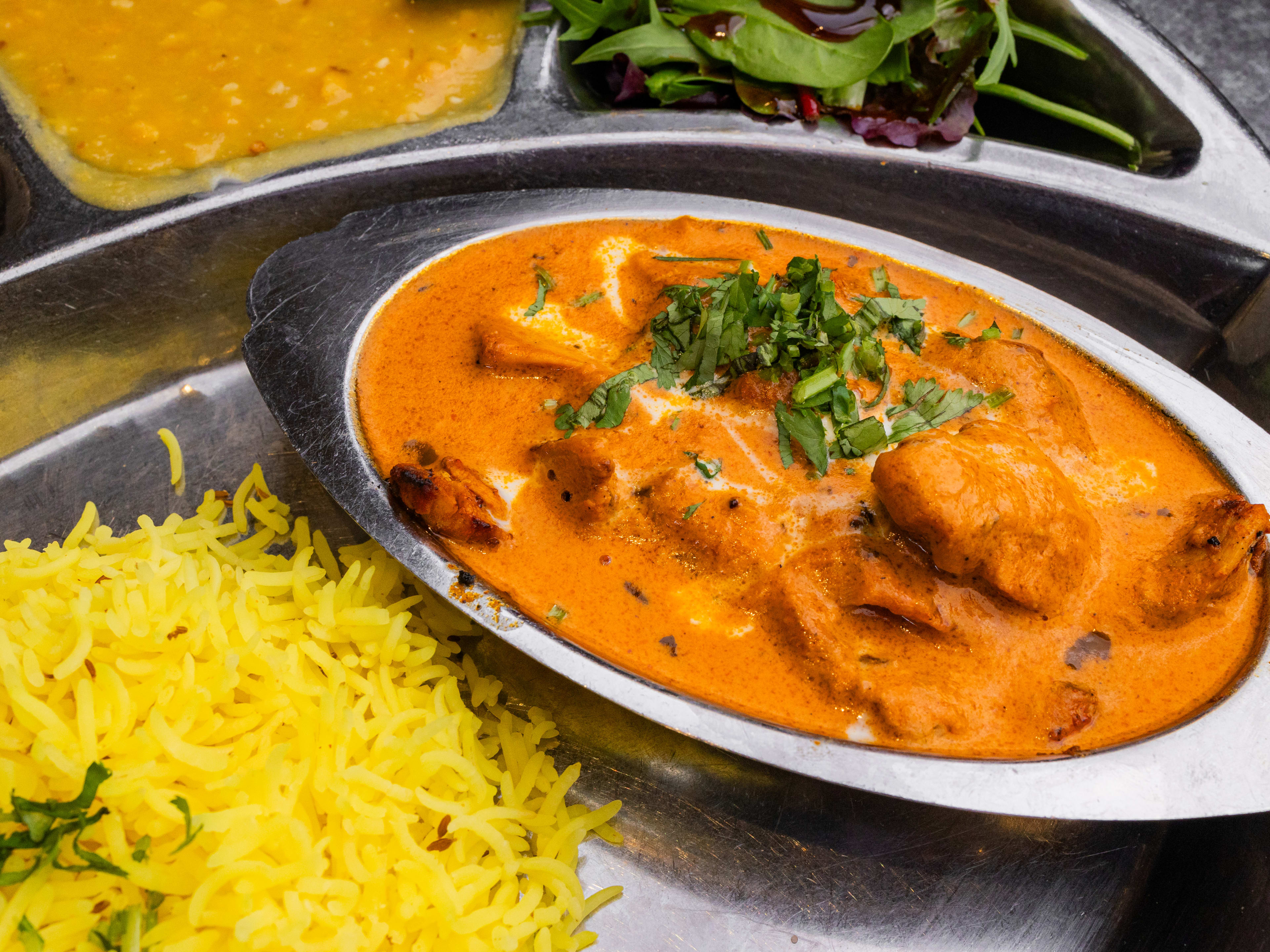 chicken tikka masala in a tin dish and rice