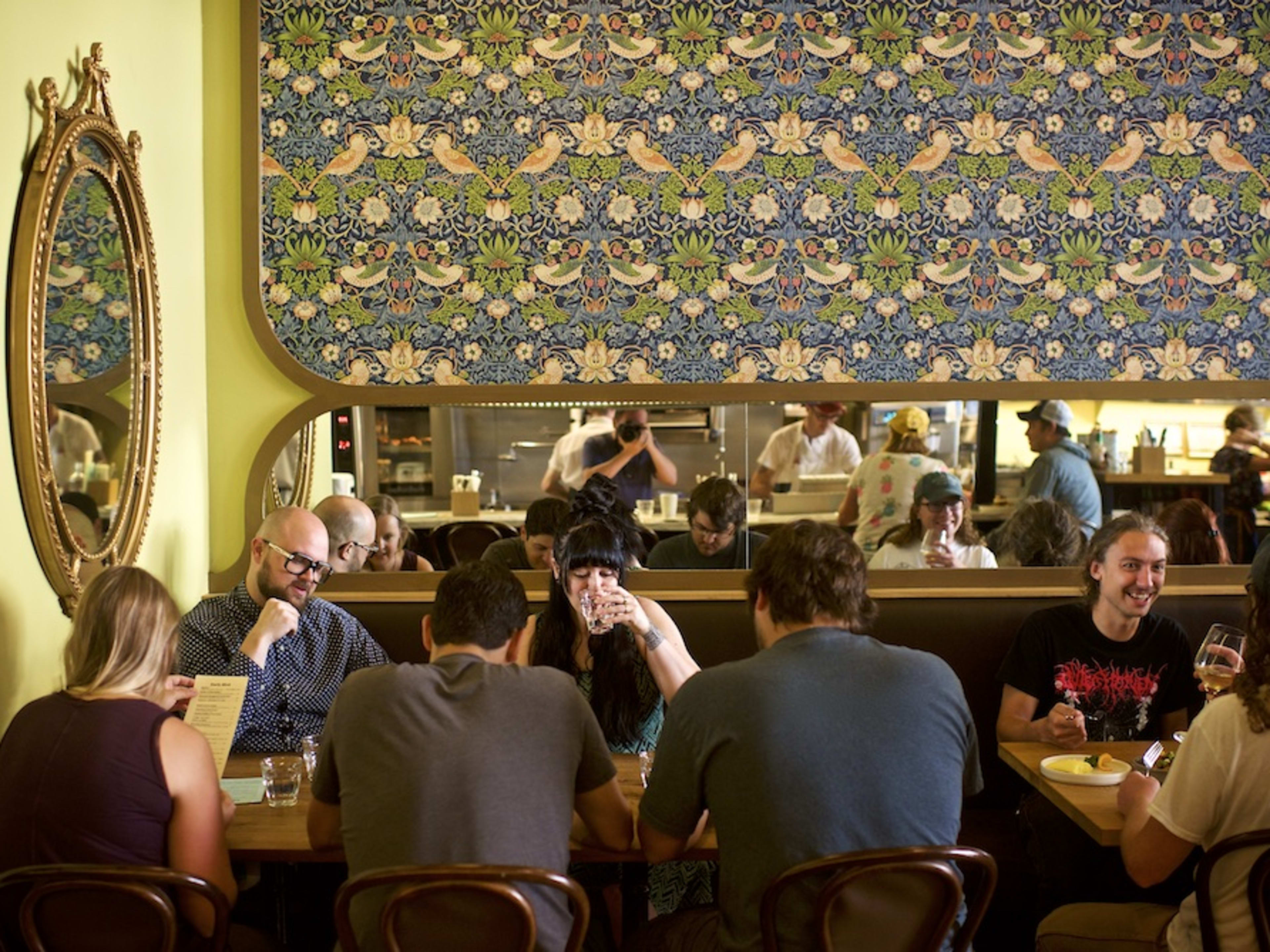 Lively interior dining space with colorful wallpaper at Canard