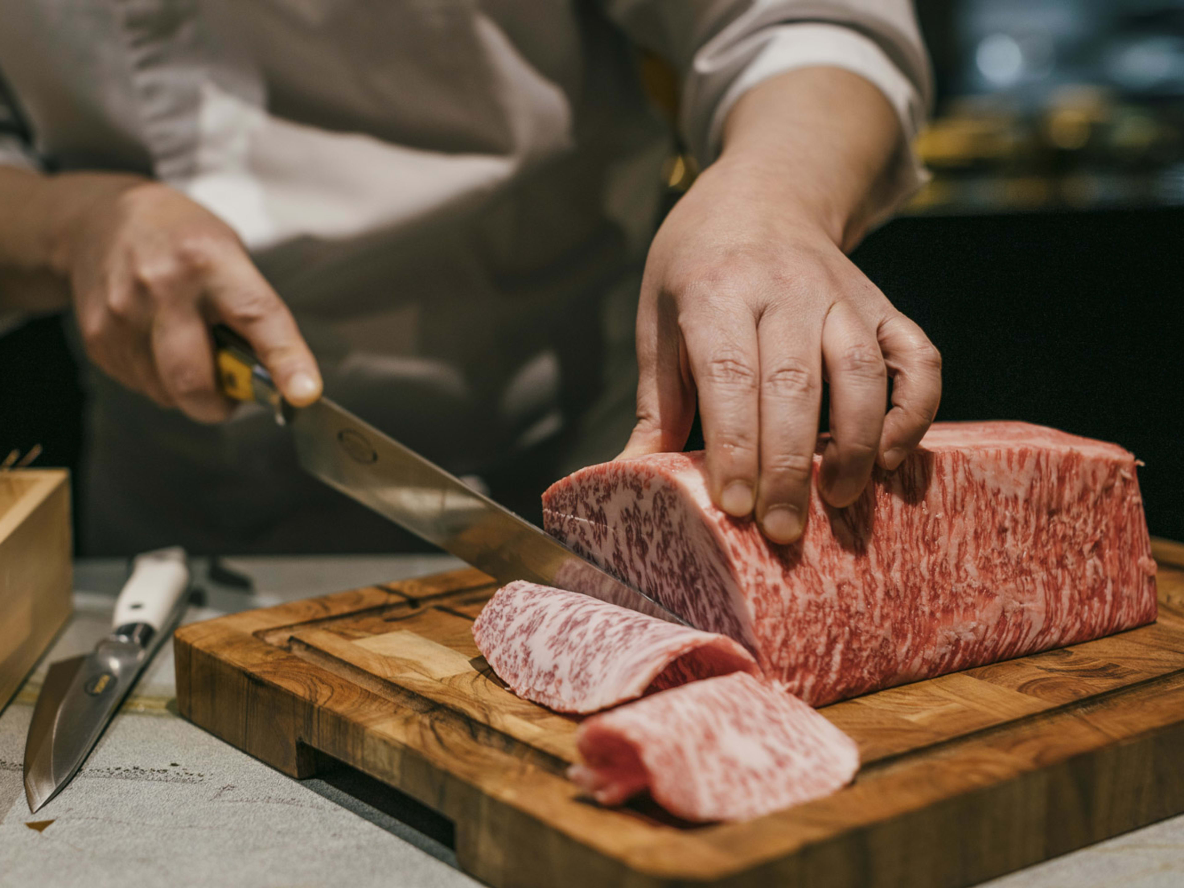 wagyu is sliced by chef for the sukiyaki