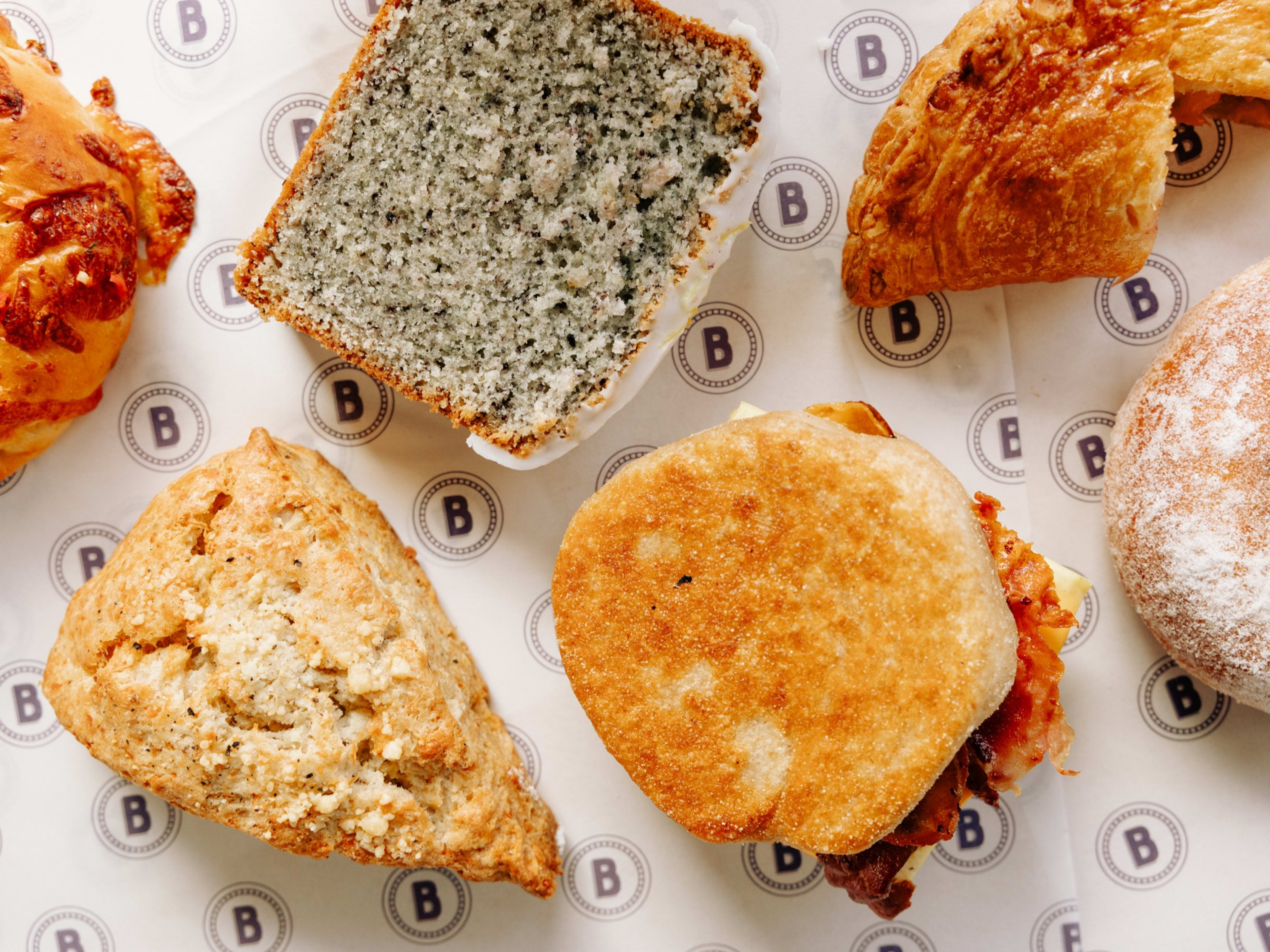 Various pastries, like a turnover, blue corn pound cake, sourdough english muffin, pecorino black pepper scone, and savory danish.