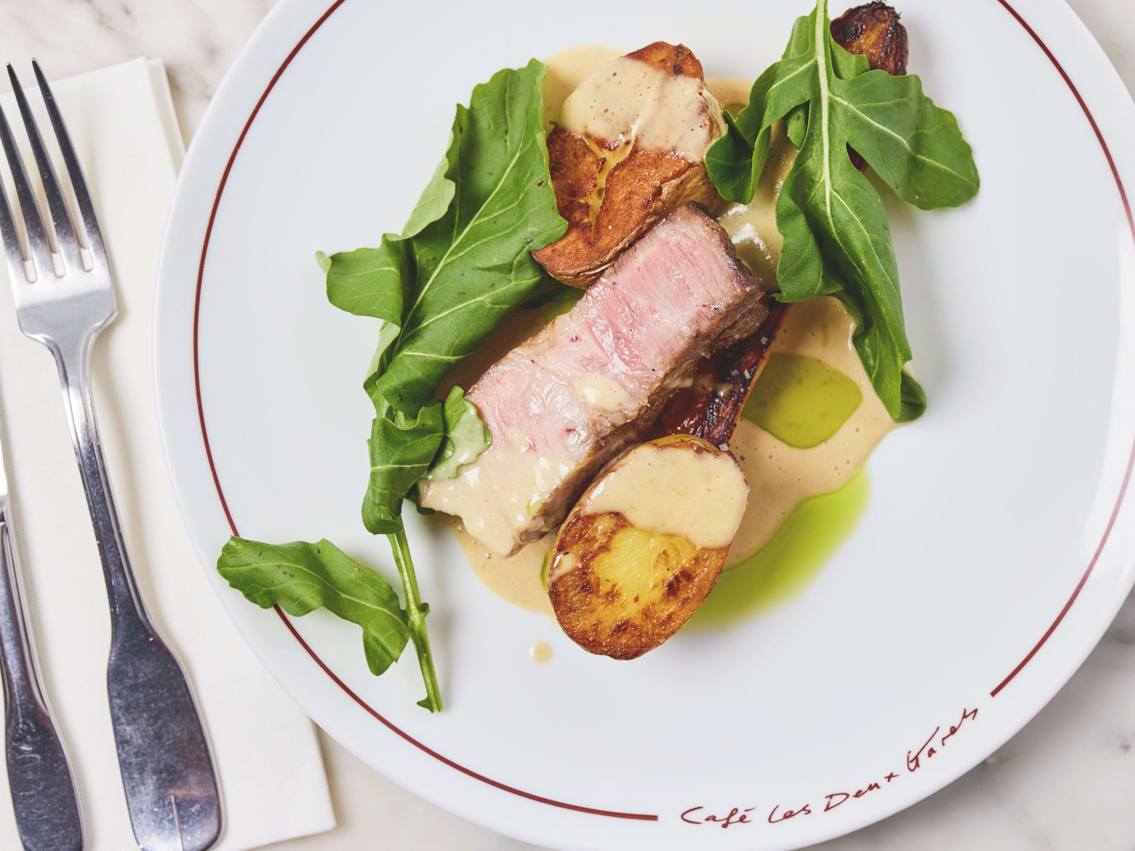 Grilled steak and roasted potato dish at Cafe Les Deux Gares