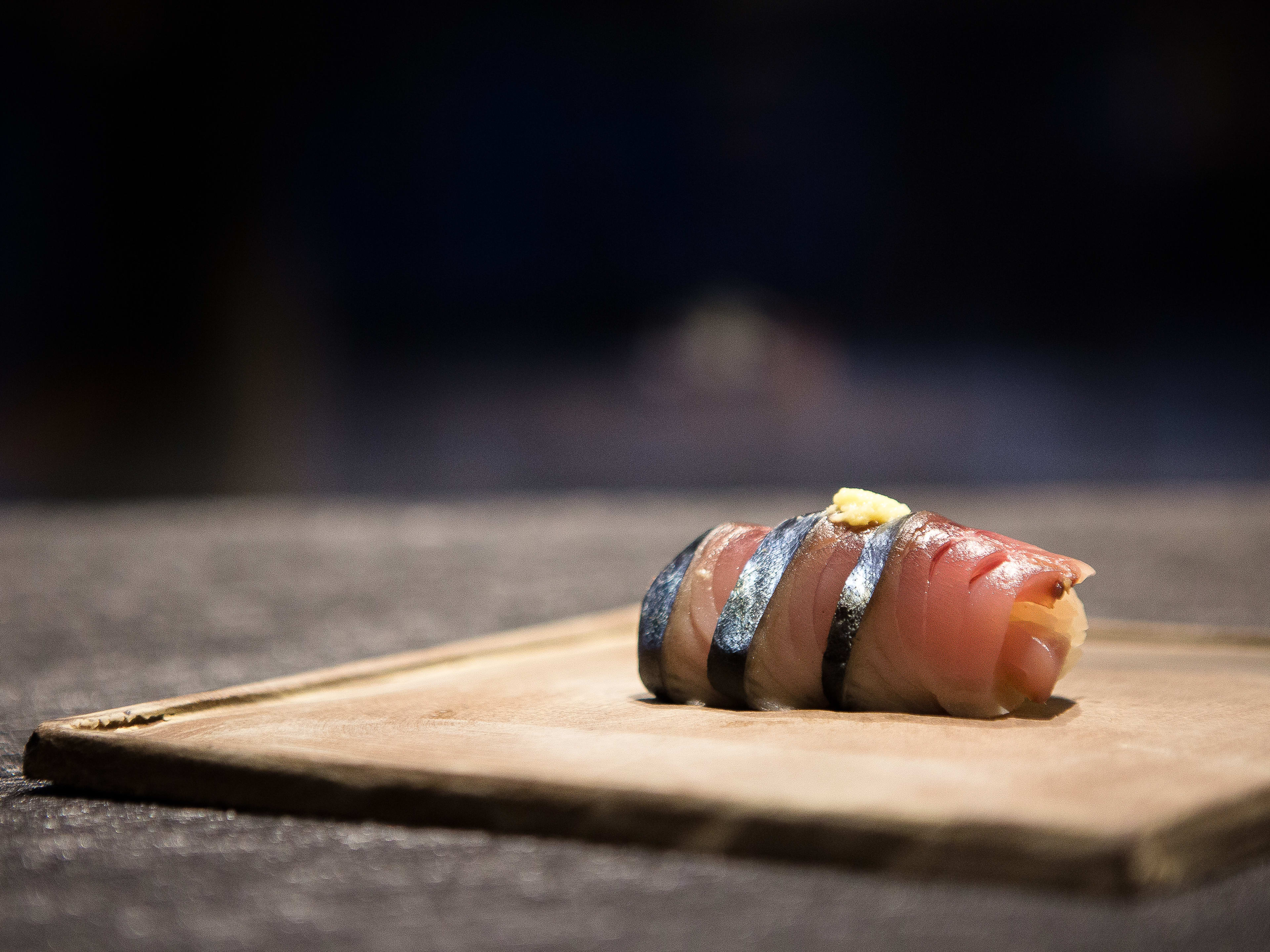 A piece of nigiri on a wooden board.