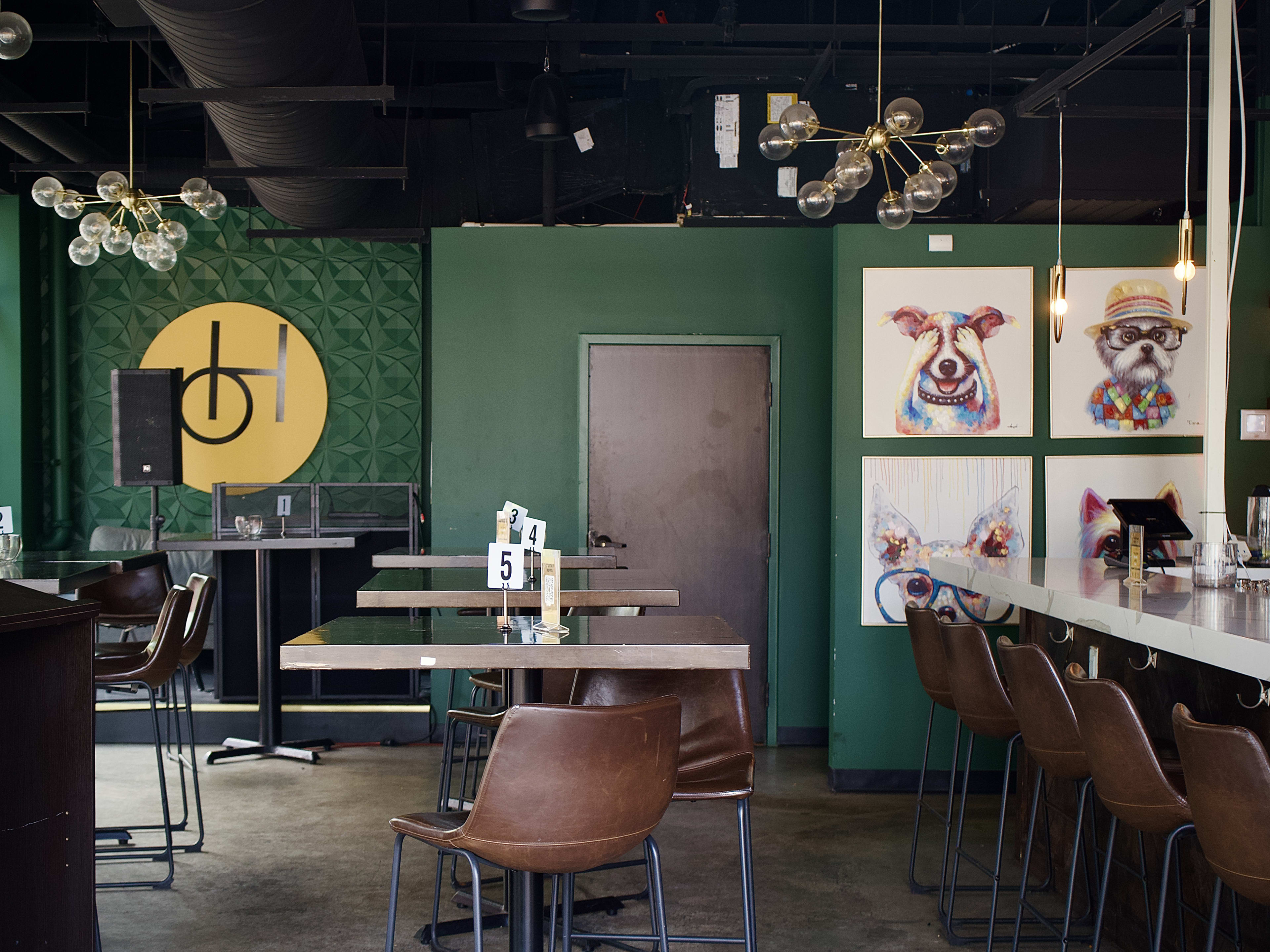 Interior dining and bar space with green painted walls at PH Craft Cocktails