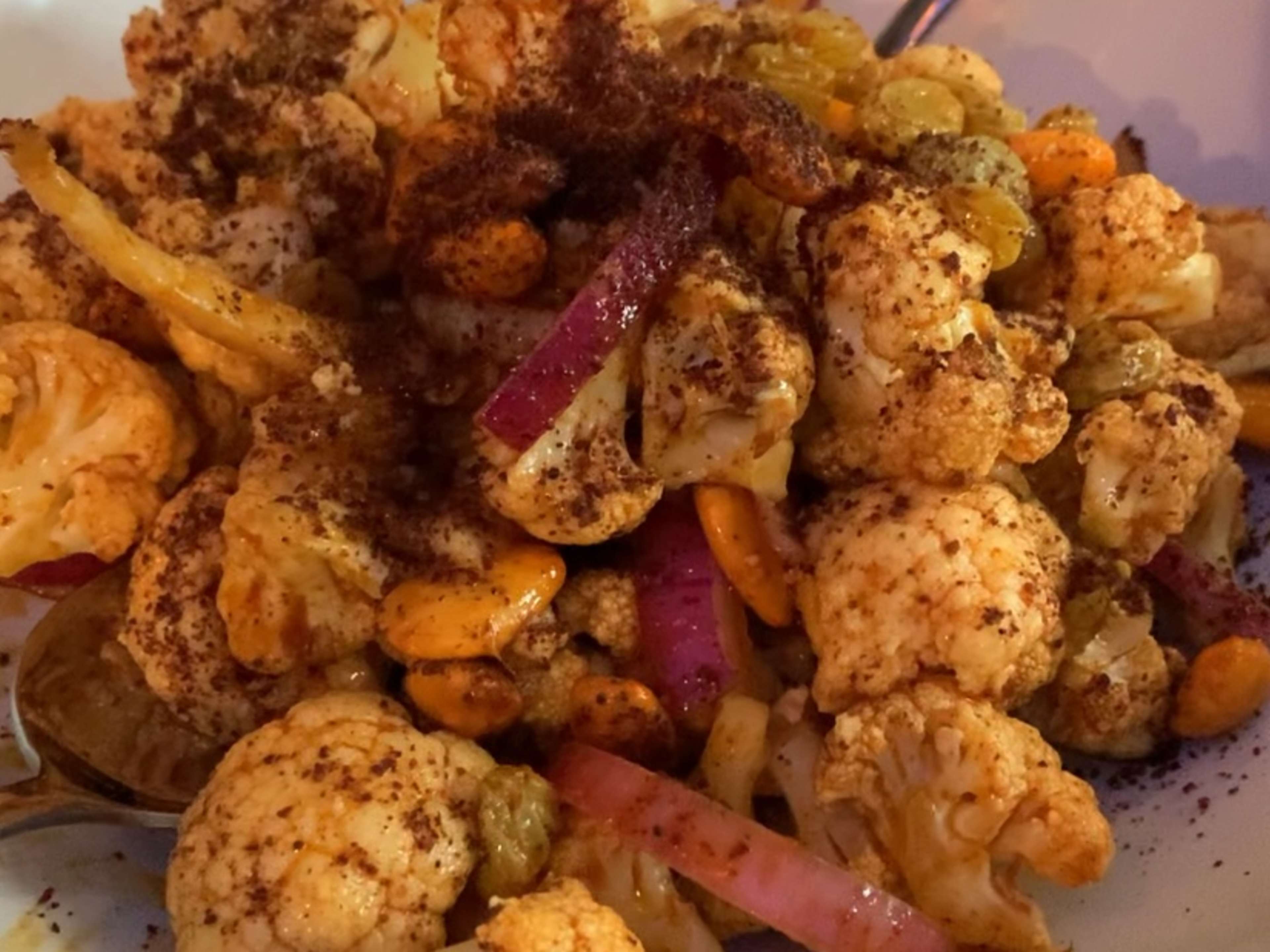 Plate of cauliflower salad with red onions, golden raisins, and cherry vinaigrette