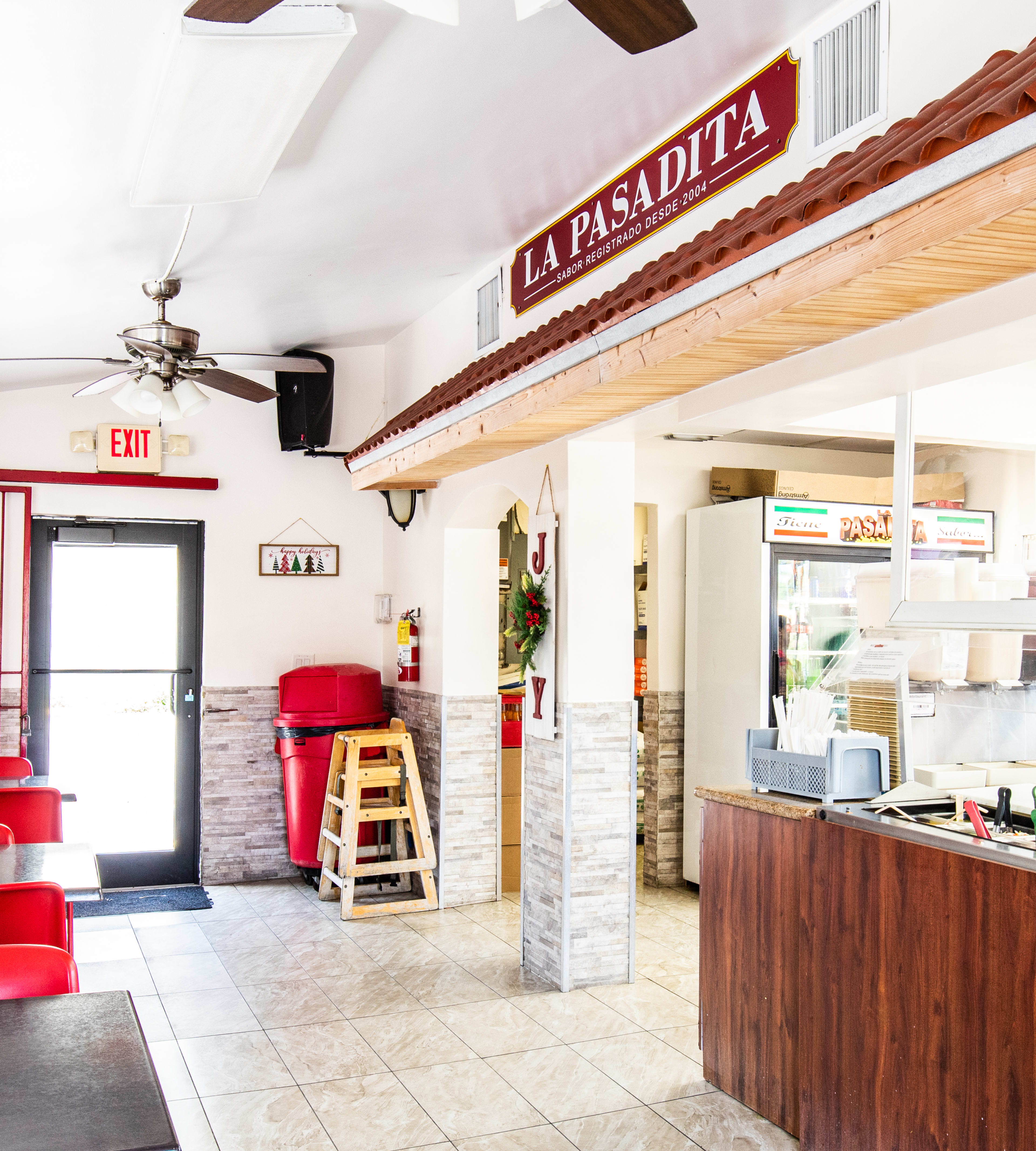 Interior of La Pasadita with condiment bar and tables with chairs.