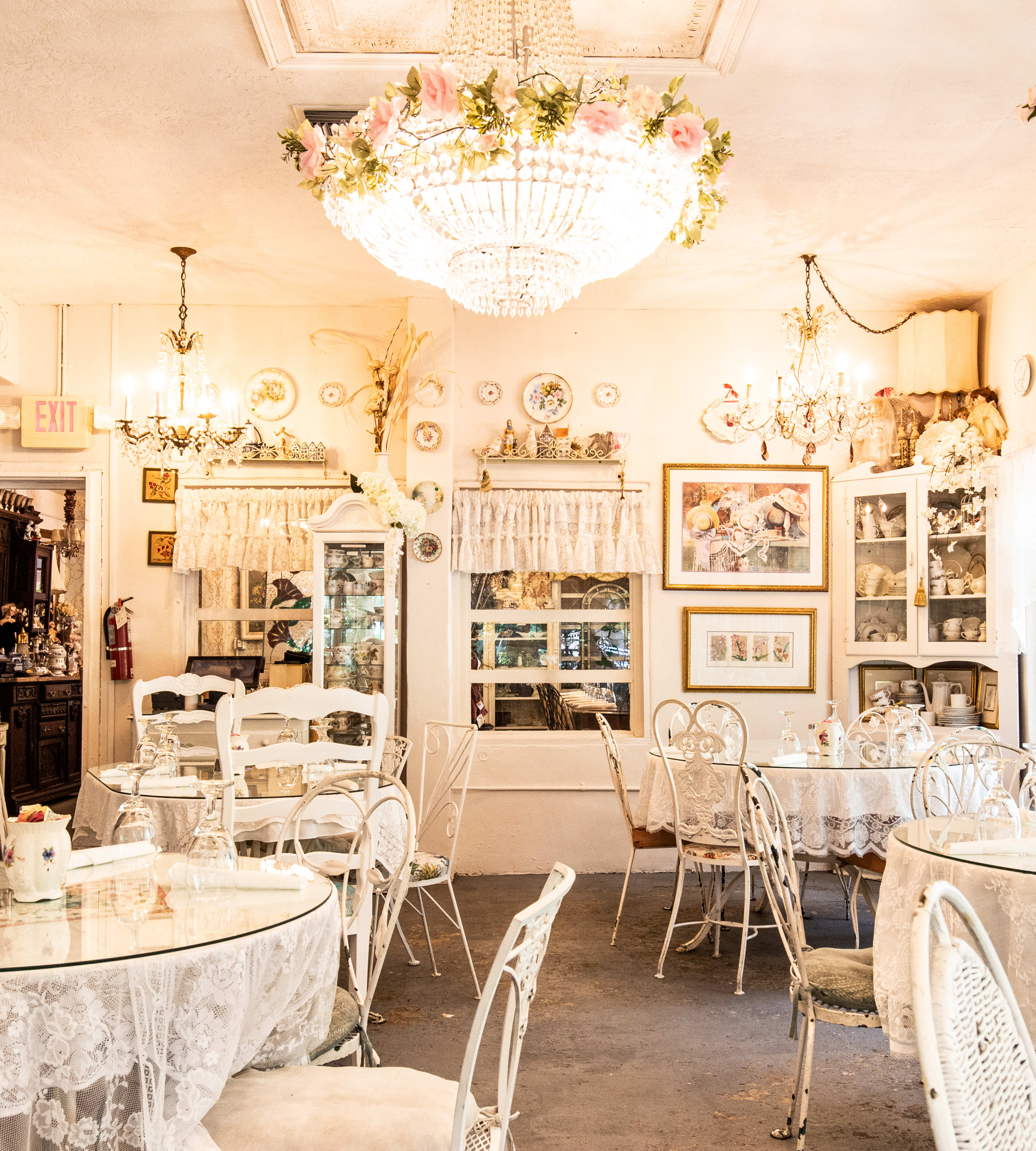 A pink dining room with circular glass tables.