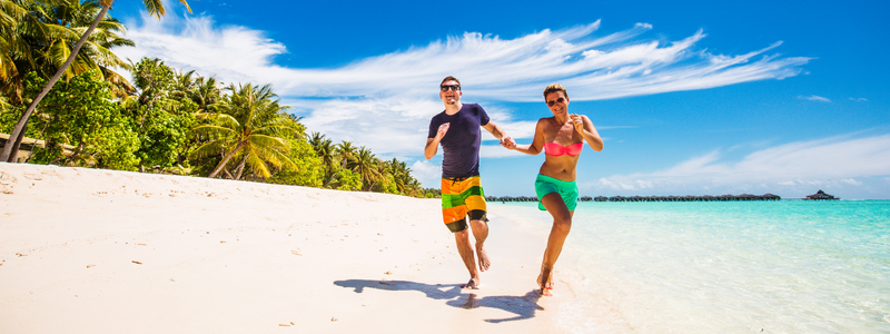 Romantic young couple running on beach 