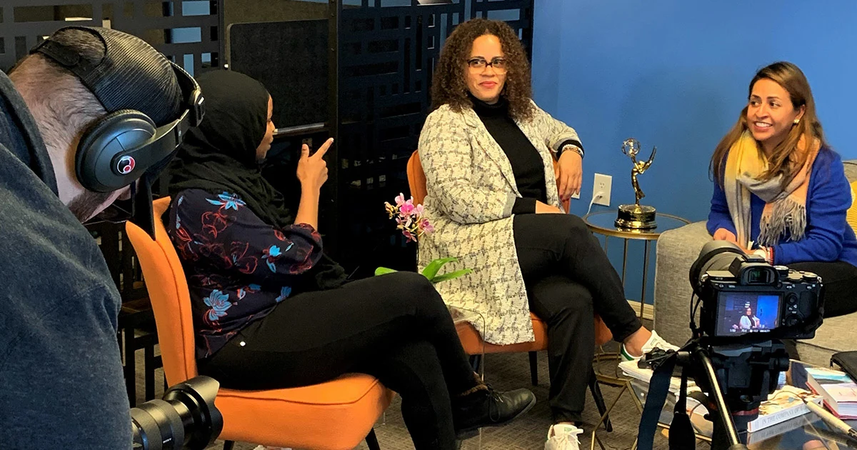 Amalia Martino and Mafe Cobaleda- Yglesias sitting down being interviewed on camera.
