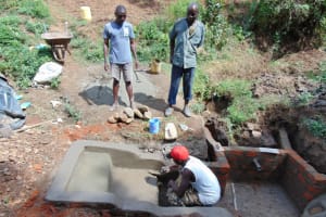 The Water Project: Mwichina Community, Shihunwa Spring -  Adding Cement