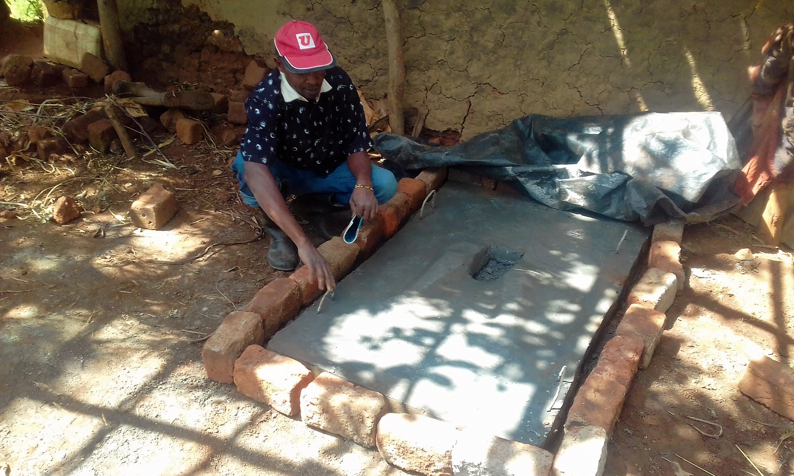 12 kenya4724 Mr. Benard poses at his new sanitation platform