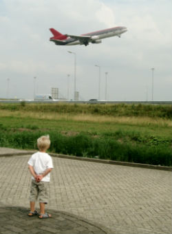 A child watching a plane take off