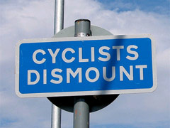 A sign for cyclists advising them to dismount