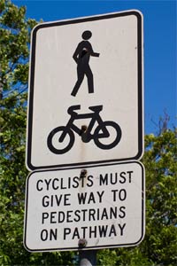 Cyclists give way to pedestrian sign