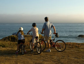 Dad and kids out on a cycling day by the sea