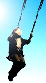 a boy in a playground playing on a swing