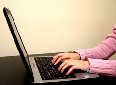 A woman typing on a laptop