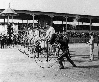 six-day-bicycle-racing-event cyclists on high wheel bicycles line up at a racing event