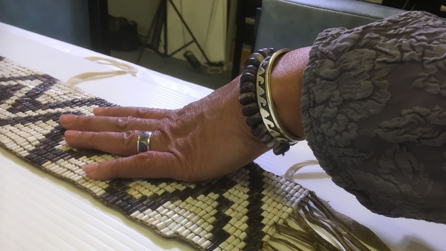 A pair of hands holding a wampum belt