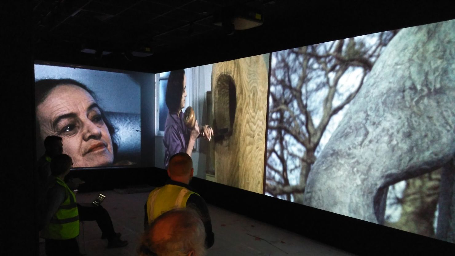 People standing in front of a large screen projection