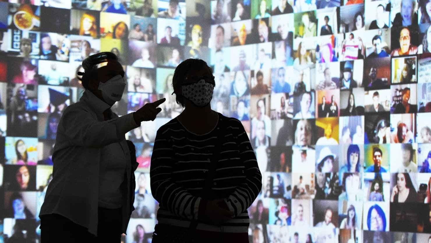 Two visitors looking at a film projection at The Box, Plymouth