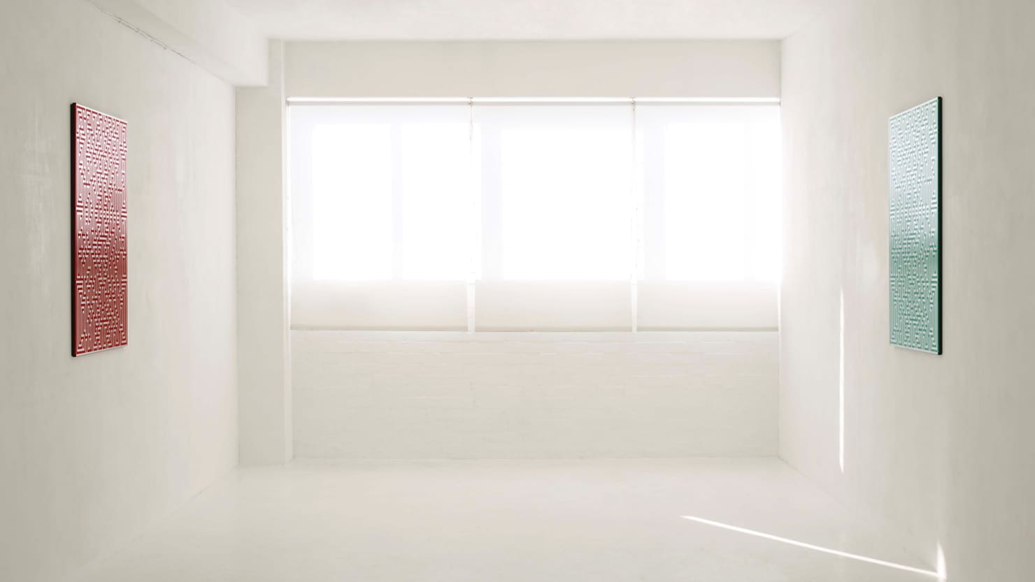 exhibition space with two artworks hanging to the left and right of a window.