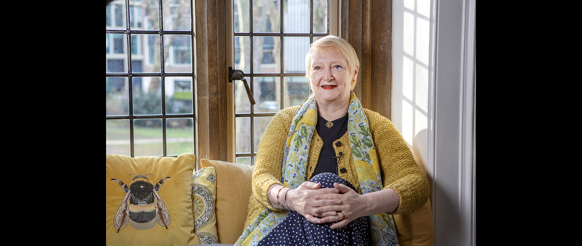 Deborah Henry-Pollard in front of a window, with yellow soft furnishings