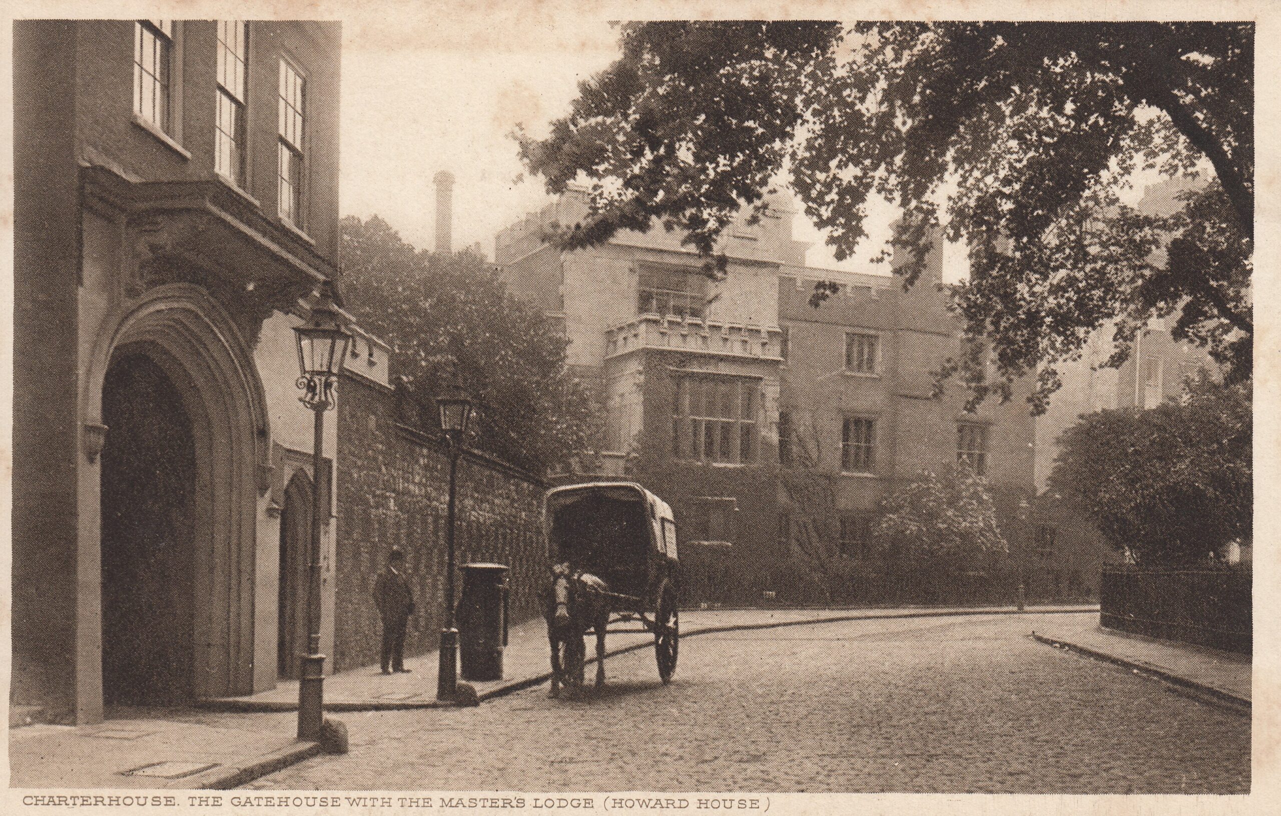 A man standing in front of a medieval gateway and wall looking at a horse and cart