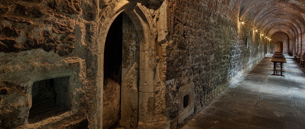 Viewof the remains of a medival monk's cell in the remains of a closter wall incorporated into an arched brick Tudor garden gallery