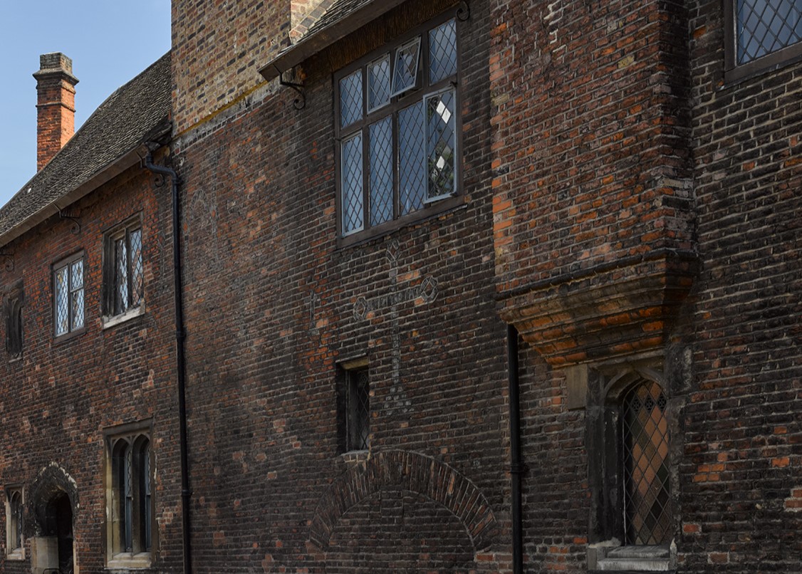 view of the external wall of Wash-House Court at the Charterhouse with symbols and lettering in the brickwork