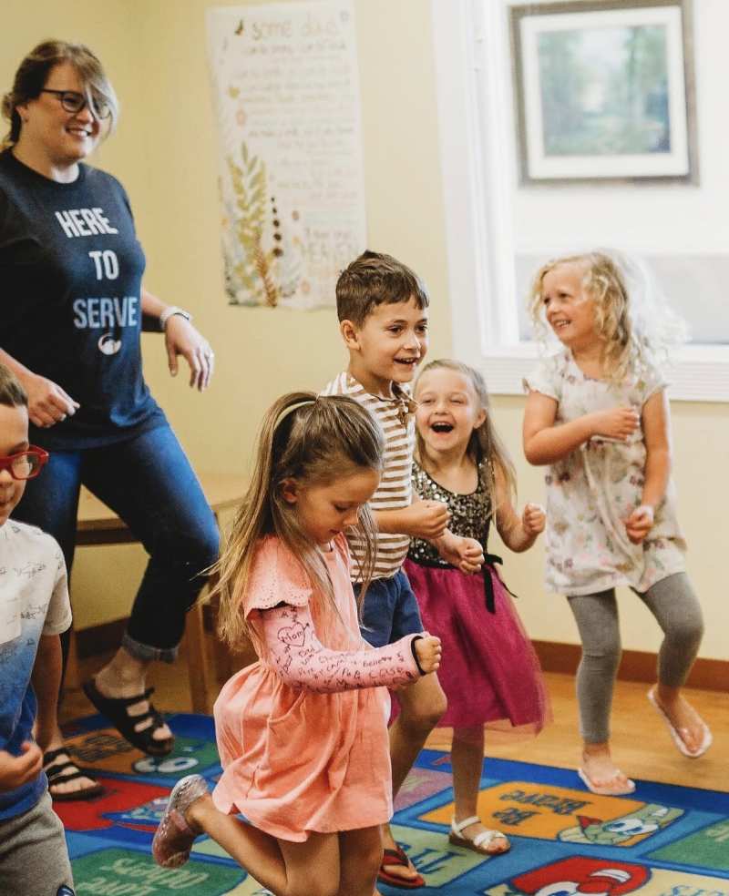 Children smiling and dancing in a Kingdom Kids classroom