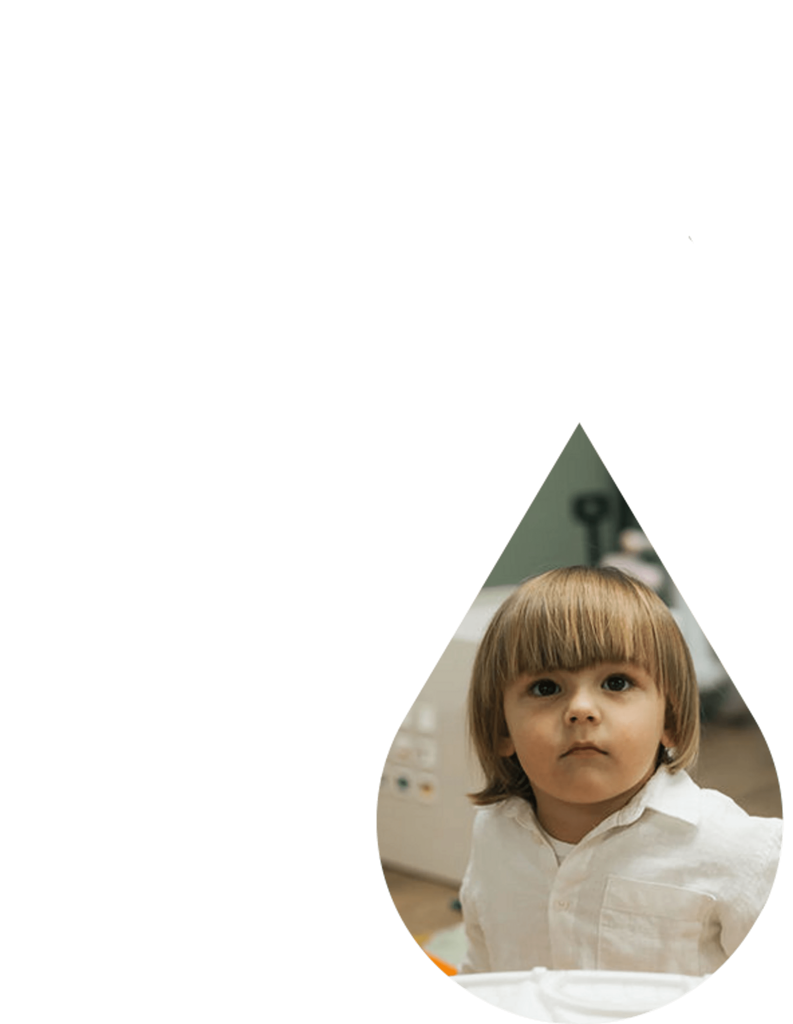 A young boy with big brown eyes and a bowl haircut, wearing a white shirt, looks forward. His image is framed inside a teardrop shape on a white background.