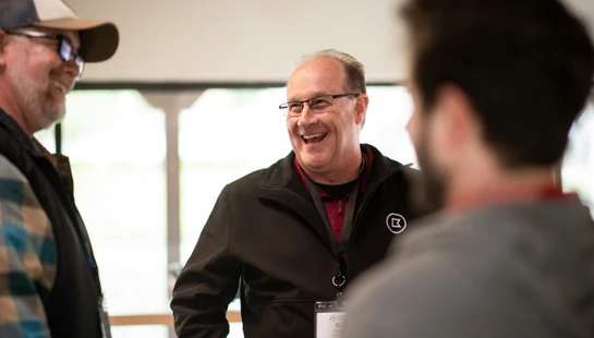 a man smiling with other men
