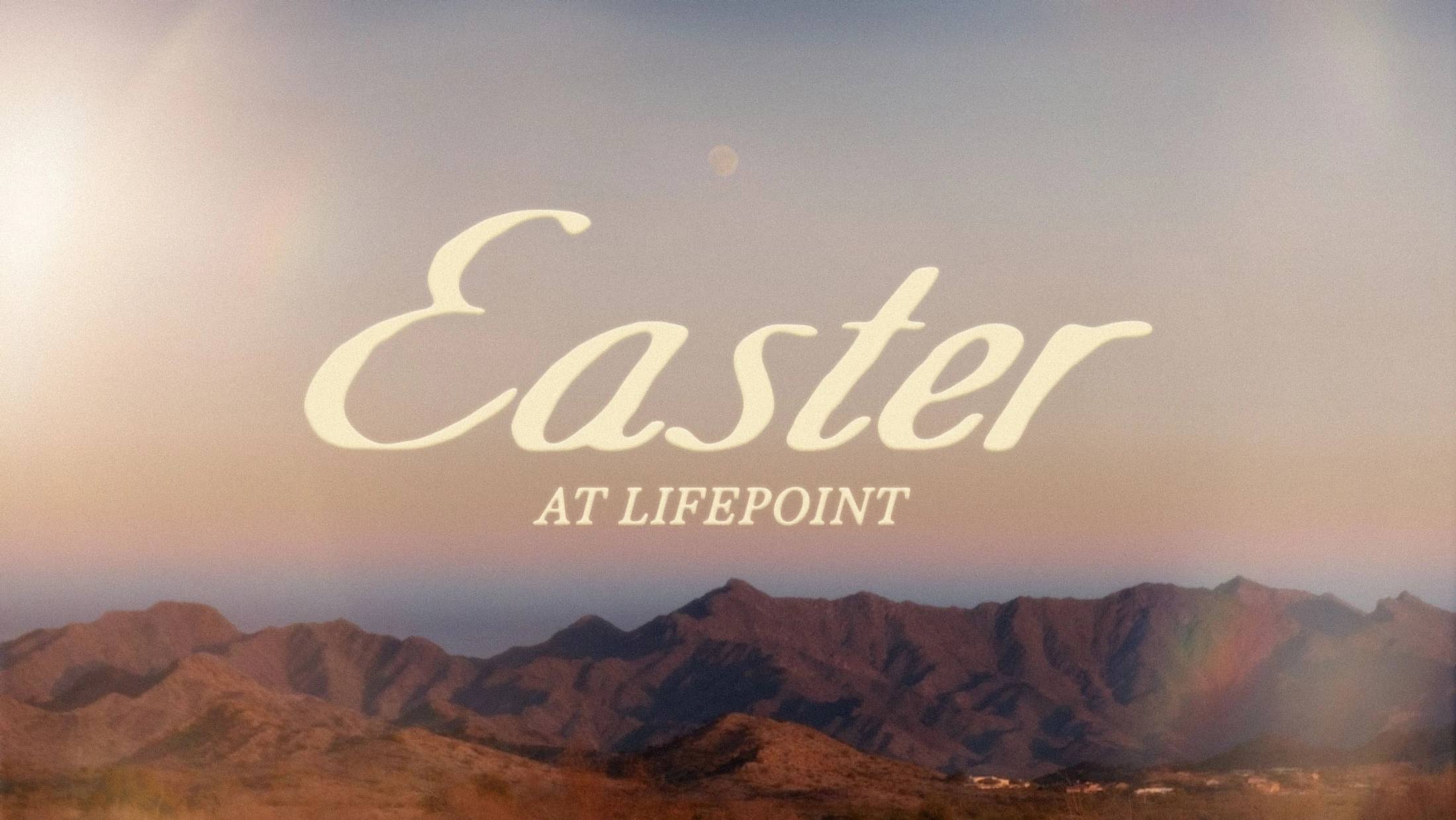 The words 'Easter at Lifepoint' in an elegant font over a scenic, hazy view of a mountain range at sunrise, with soft light and a subtle rainbow.