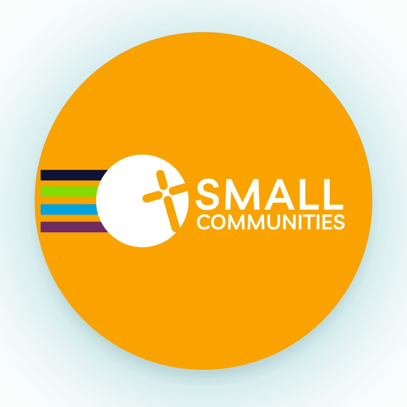 A logo for Small Communities inside an orange circle. The logo includes colorful stripes and a stylized cross on a teal, circular background.
