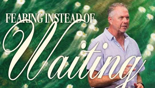 A man speaks into a microphone against a background of a green daisy field, with the words 'Fearing Instead of Waiting' overlaid on the image.