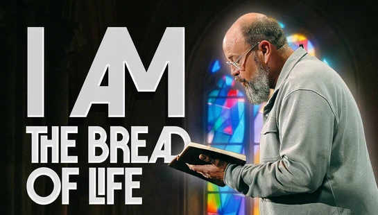 A pastor with a beard and glasses holds a Bible in front of a stained-glass window. The text on the image reads, 'I AM THE BREAD OF LIFE'.