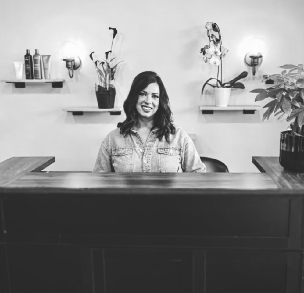 Lauren Prost welcoming guests at the front desk of The Collective luxury hair salon in Green Bay, Wisconsin.