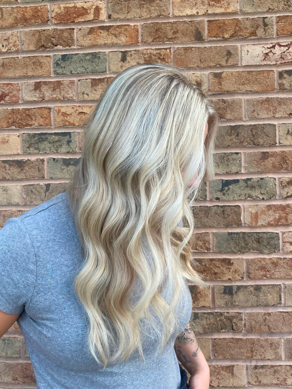 Long blonde wavy hair styled at a hair salon in Green Bay, Wisconsin.
