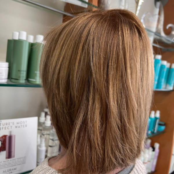 Layered blonde haircut with warm highlights styled by Green Bay WI hair stylist Kassandra Simonar.