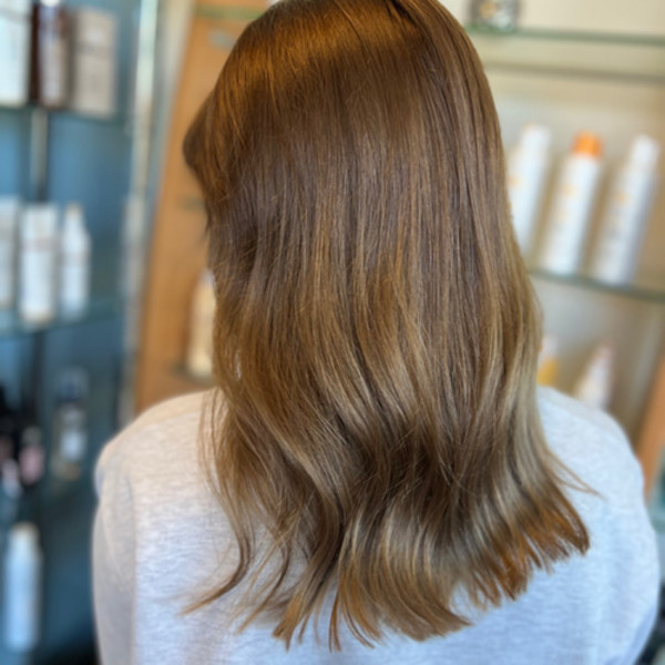 Medium-length brunette hair with soft, natural highlights styled by Green Bay hair expert Kassandra Simonar.
