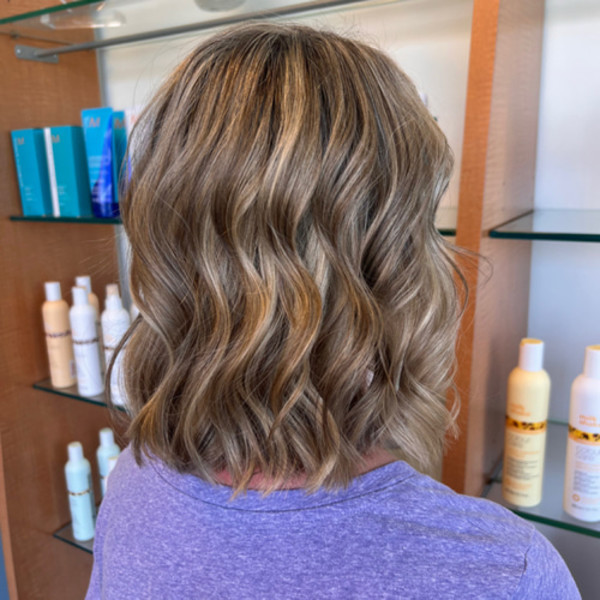 Short blonde wavy bob with subtle highlights styled by Green Bay WI hair professional Kassandra Simonar.
