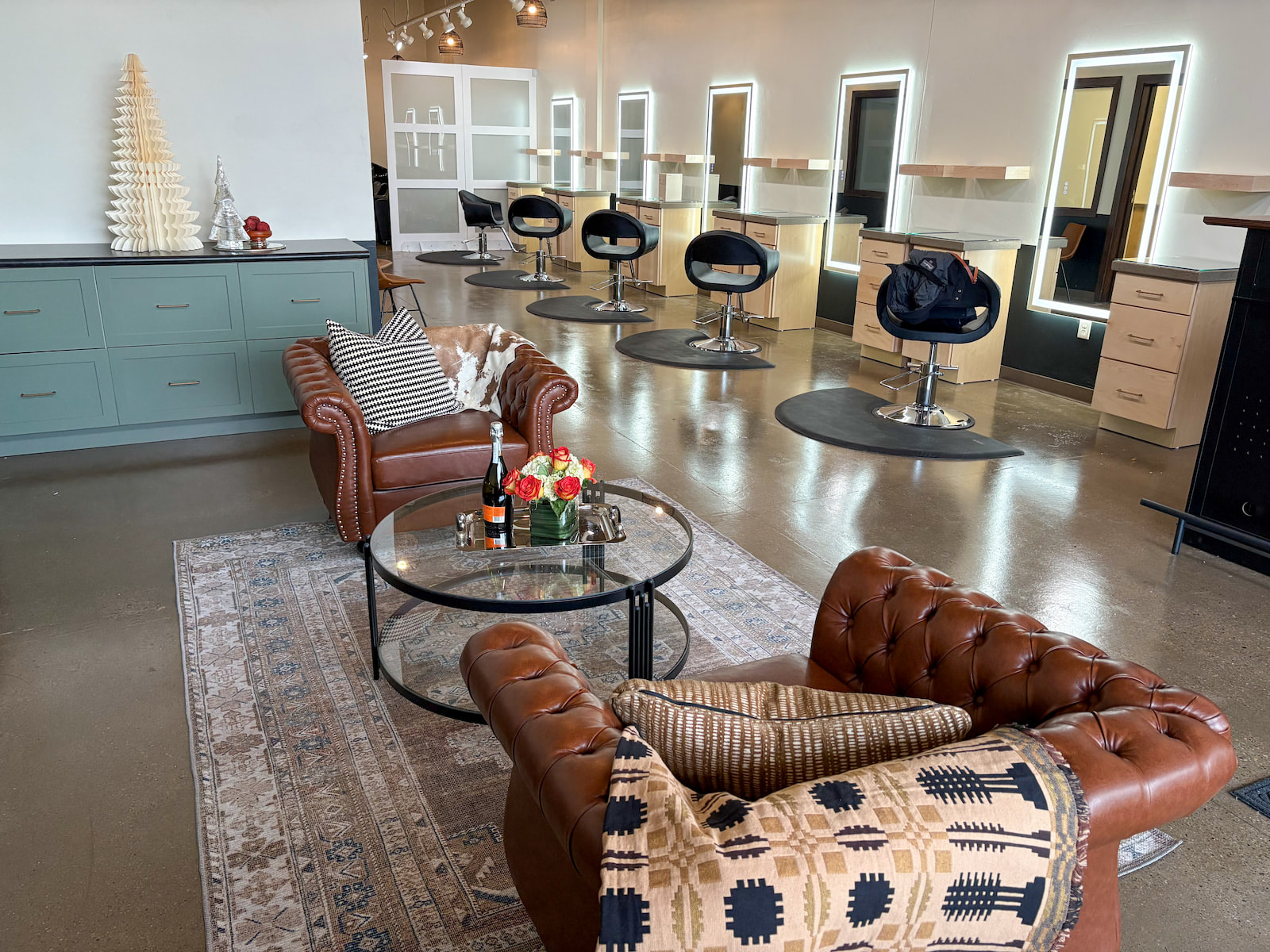Spacious Green Bay hair salon with leather seating, lighted styling stations, and modern decor.