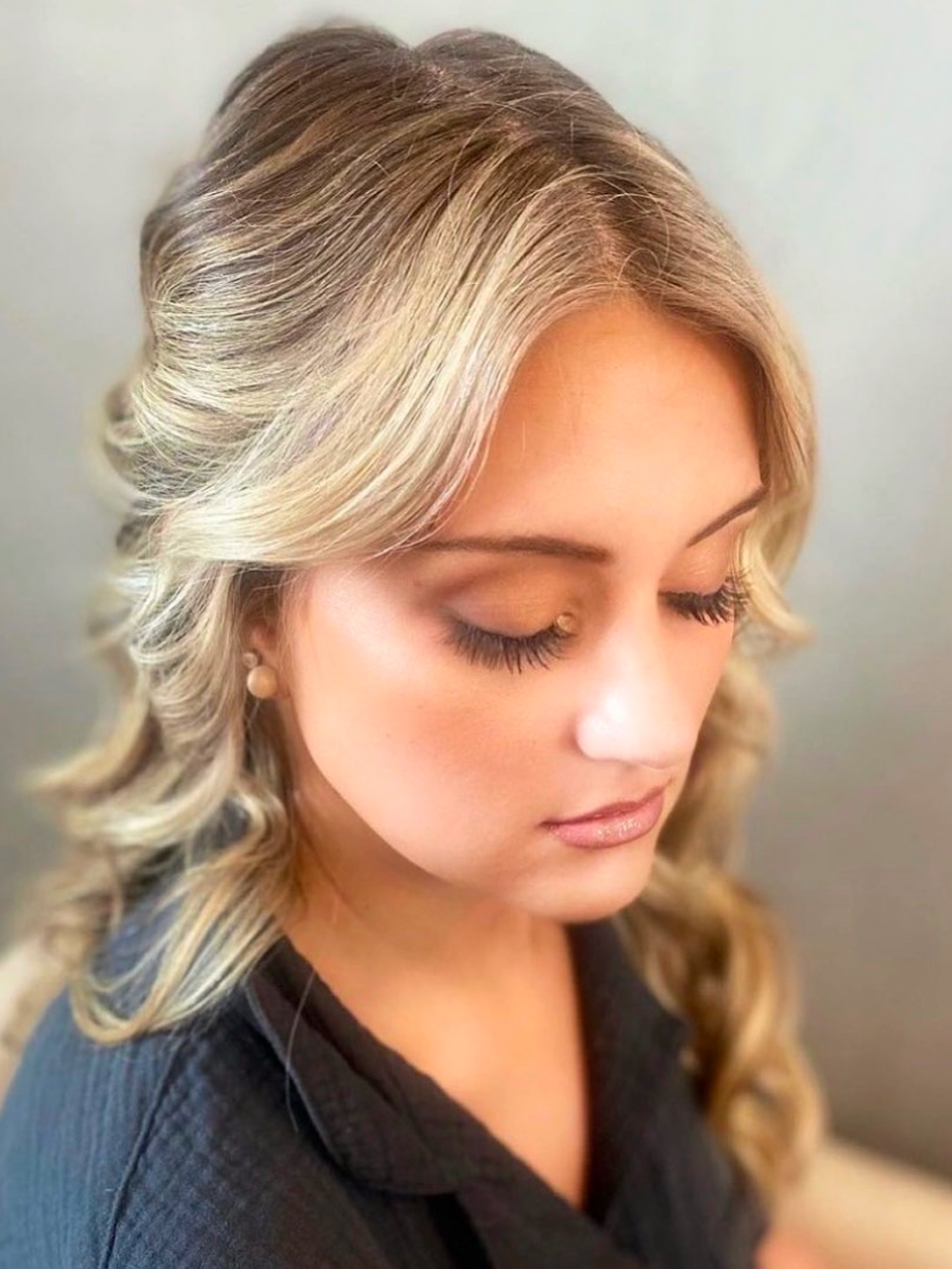 Soft half-up curled blonde hairstyle by Lauren Prost at The Collective salon in Green Bay, Wisconsin.