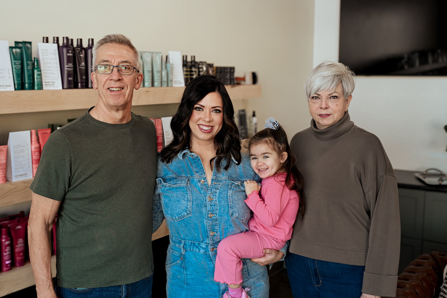 Lauren Prost posing with family members inside The Collective luxury hair salon in Green Bay, Wisconsin.