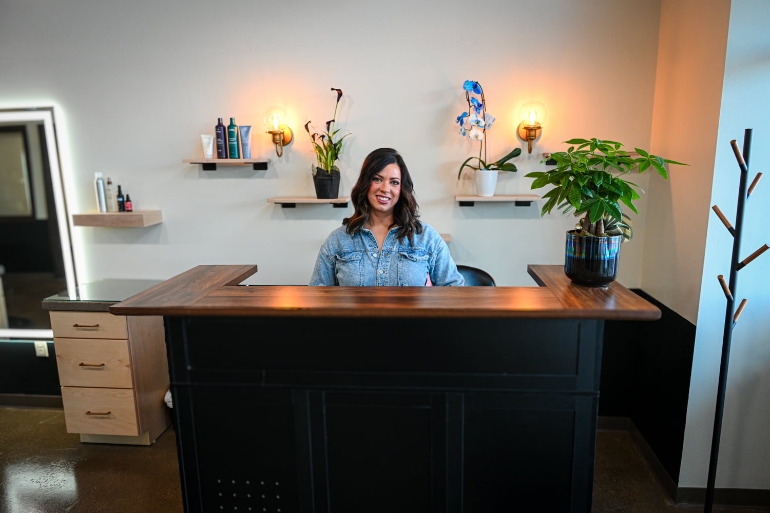 Lauren Prost welcoming guests at the front desk of The Collective luxury hair salon in Green Bay, Wisconsin.